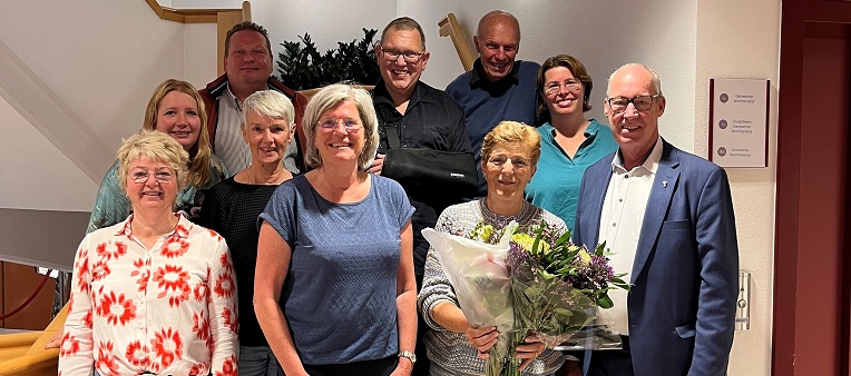groepsfoto met leden van de Adviesraad Sociaal Domein en wethouder Tjeerd Pietersma. Scheidend secretaris Liesbeth Rijken met bloemen in de handen.