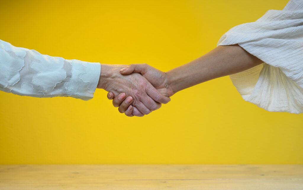 Twee mensen met verschillende achtergronden geven elkaar een hand