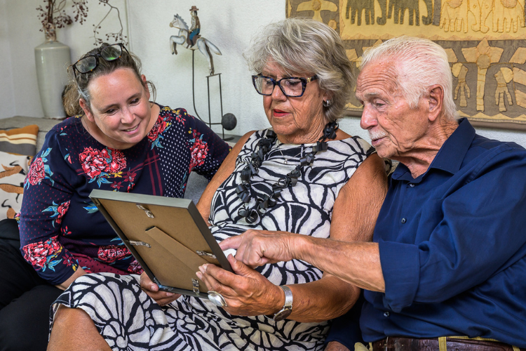 Echtpaar Douw-Snijder bekijkt oude foto samen met burgemeester Judith Michel