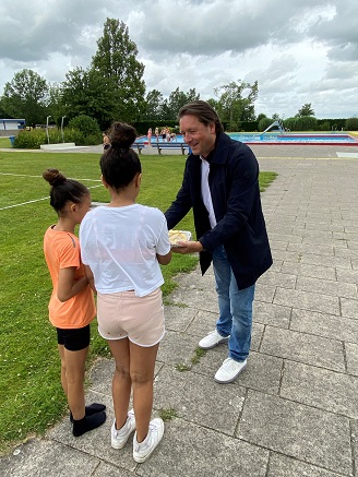 Wethouder Ossendorp deelt fruit uit aan kinderen tijdens sportweek